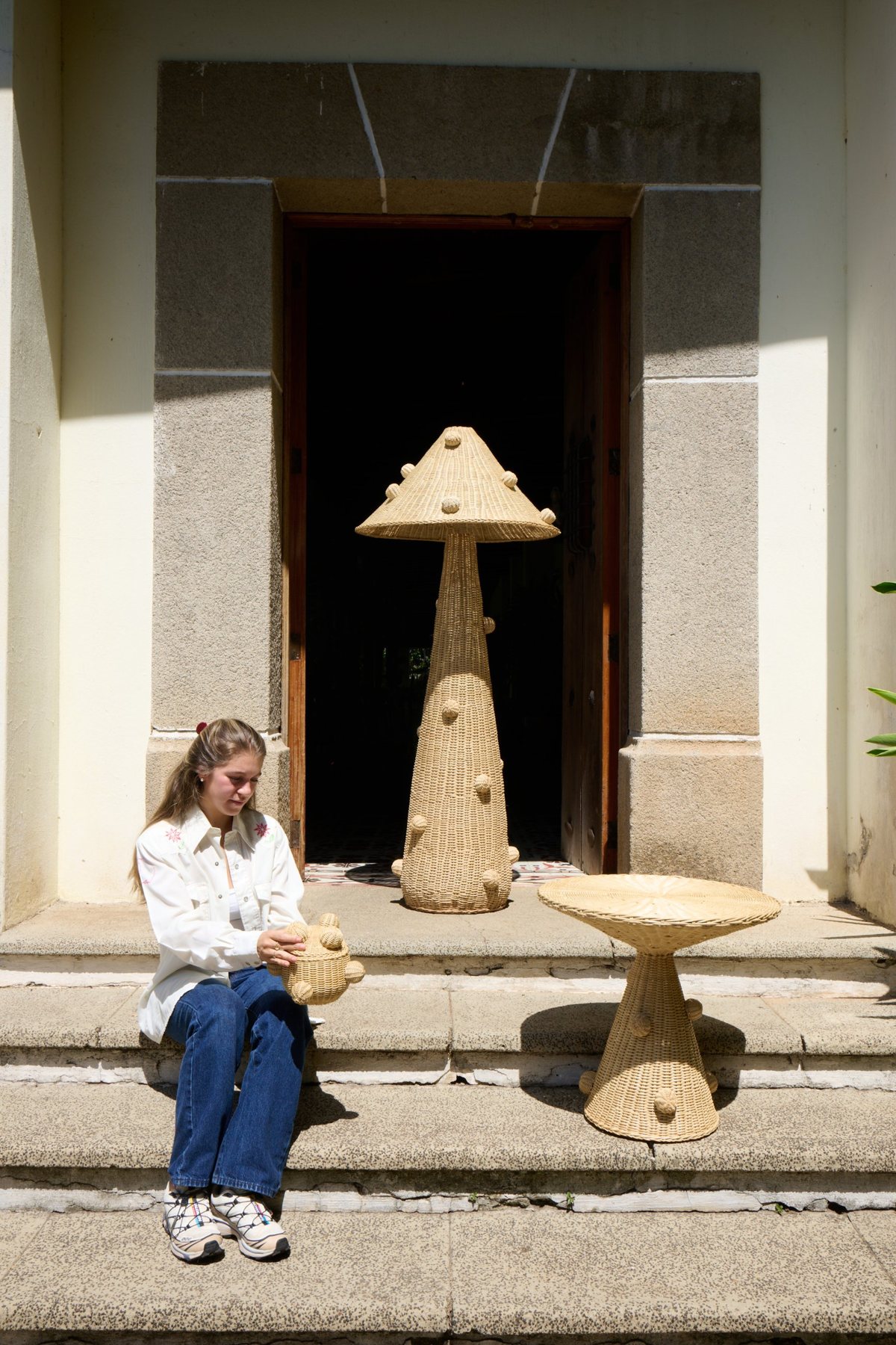 Catalina on stone steps with the Hongo floor lamp and Semilla side table