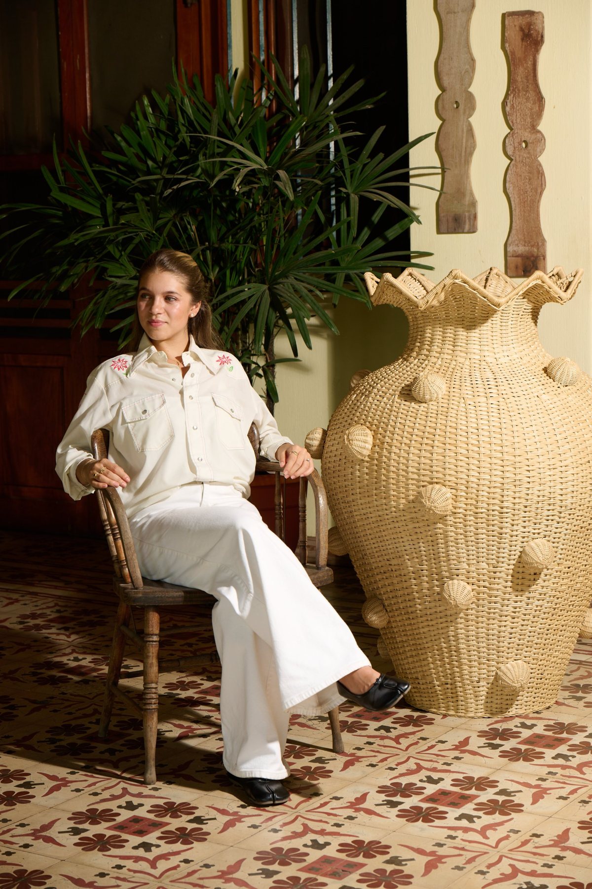 Catalina seated beside a large handwoven Cálamo vase